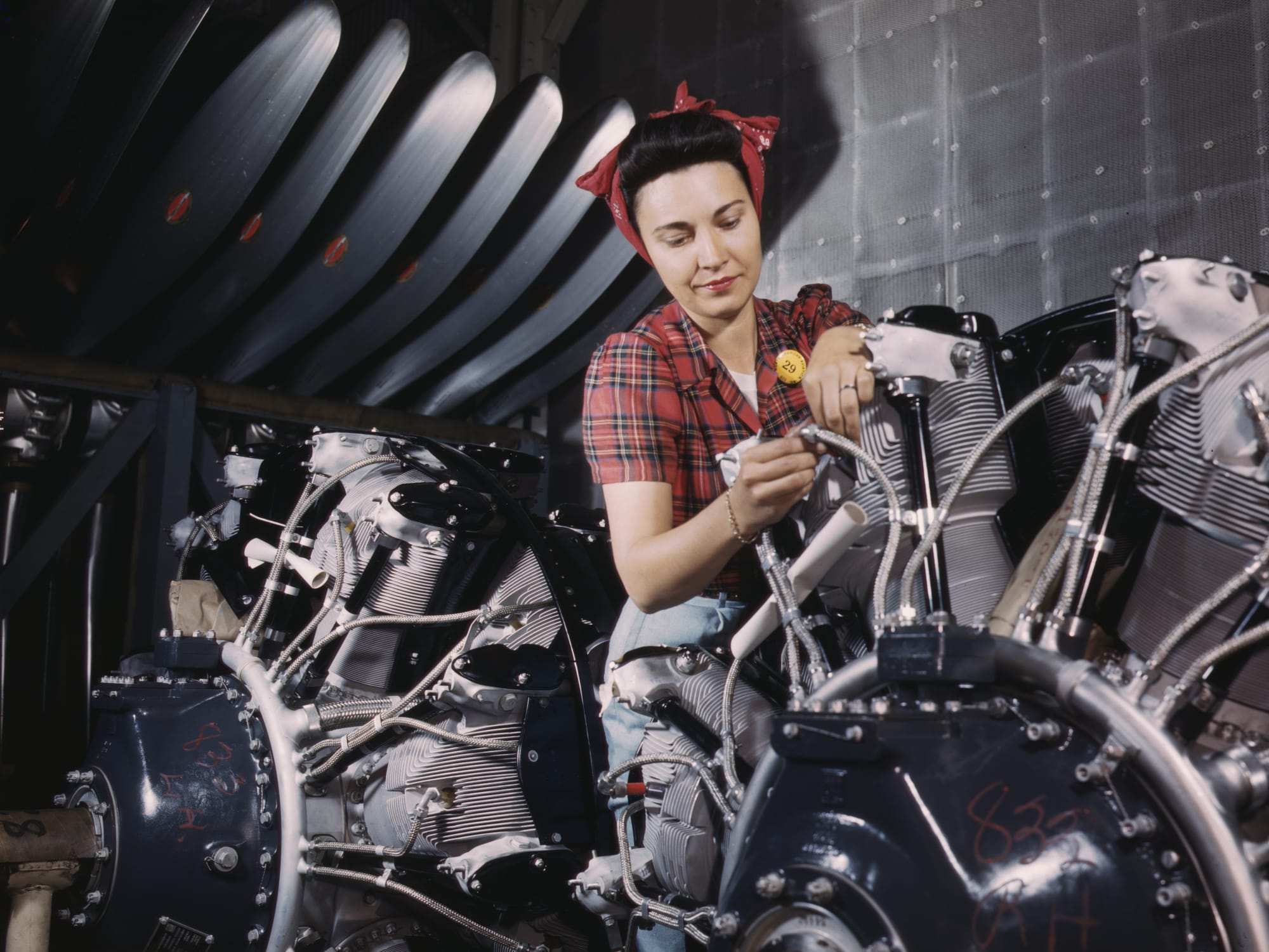 A woman working on an airplane motor at the North American Aviation, Inc, plant in Inglewood, California, 1942. Library of Congress.